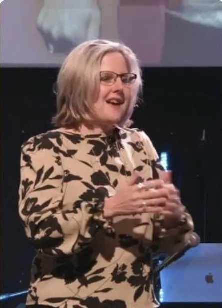 Kim Gilson laughing with the audience mid-talk